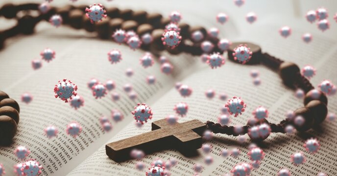 Covid-19 cells against rosary on bible