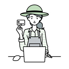 デスクで座ってPCを使いながらクレジットカードを手に持っている農家の女性