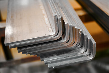Fototapeta Long bent metal details stacked at production plant obraz