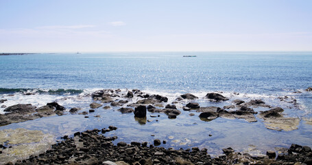 Fototapeta na wymiar Stone rock sea beach with sunny sky