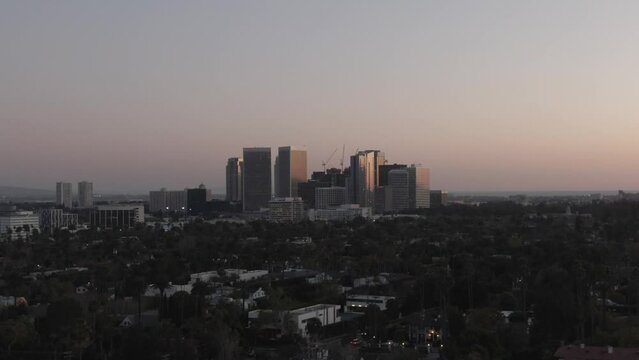 Beverly Hills downtown skyline at dusk with homes in foreground aerial view