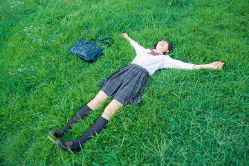 芝生に寝転ぶ女子高生