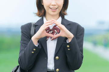 手で「マル」を作る女子高生