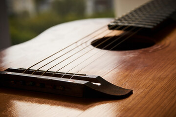 Fototapeta premium Old guitar with strings, close-up. Acoustic guitar music instrument
