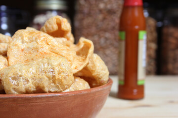 Fried Pork Skins With Hot Sauce in Rustic Kitchen