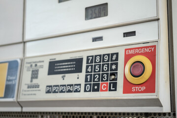 An emergency stop button on the gasoline refuel control panel machine at commercial gas station. - obrazy, fototapety, plakaty