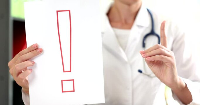 Doctor is holding paper with red exclamation mark in clinic