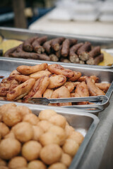 Trays of sweets at a market in Laos, focus is on the banana fritters, glutinous rice balls in the blurred foreground.
