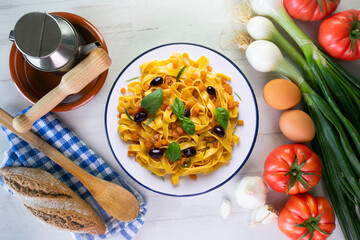Pasta ribbons with sautéed pumpkin and black olives. Traditional Italian recipe.