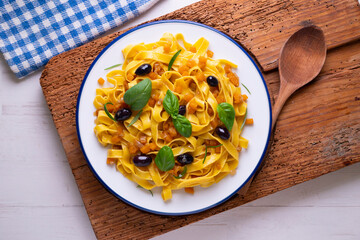 Pasta ribbons with sautéed pumpkin and black olives. Traditional Italian recipe.