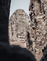Obraz premium Siem Reap, Cambodia - March 18th, 2020 : face of the Buddha carved in stone at Bayon temple in the Angkor Wat religious complex