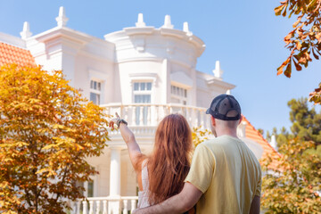 Visit to museum. Young couple of man and woman with tattoos huge on the street and look at beautiful white house. Back view. The concept of relationship psychology and purchase of real estate - obrazy, fototapety, plakaty