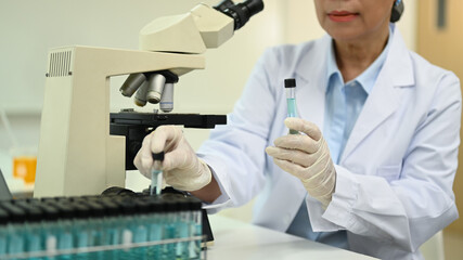 Cropped shot of senior scientist working analysis with blue liquid test tube in the science research laboratory