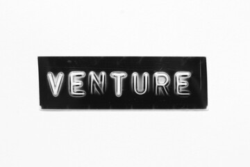 Black color banner that have embossed letter with word venture on white paper background