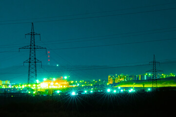 power lines at night against the city lights