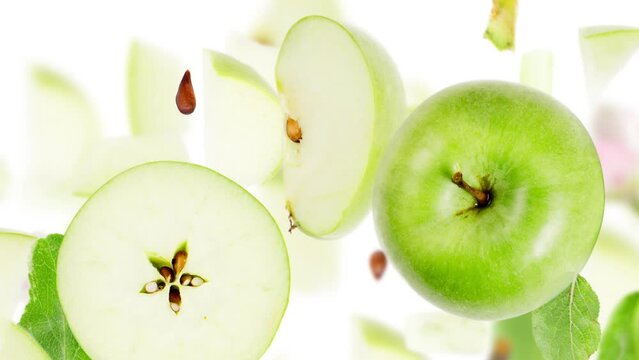 Green Apple fruit pieces, slices and leaves being falling down isolated on white. Seamless looping. High quality 4k video.