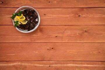 Fresh mushrooms in a plate. salted mushrooms are decorated with herbs and lemon for the festive table. food. on a wooden background. space for text.salad. Still-life.	