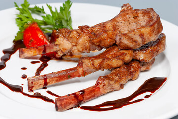 grilled lamb square with sauce on a white plate