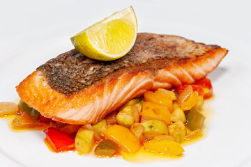grilled salmon steak with vegetables on a white plate