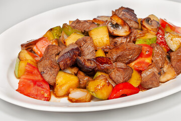 roast meat with vegetables on a white plate