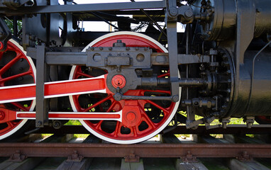 Old steam locomotive wheel and connecting rods. Coupling rod or side rod for driving wheels.