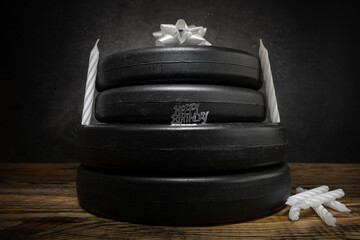 Heavy dumbbell barbell weight plates stacked on top of each other in the shape of a birthday cake,...