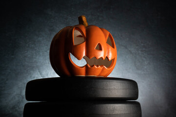 Small ceramic Halloween pumpkin on a dumbbell barbell weight plates. Healthy fitness lifestyle...