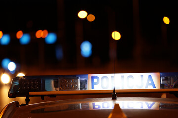 Nocna interwencja alarmowa policji - Sygnalizator błyskowy niebieski na dachu radiowozu policji polskiej w nocy. © FotoDax