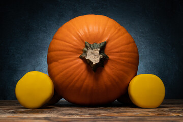 Two yellow dumbbells and orange pumpkin with stem cut off. Healthy fitness lifestyle autumn or fall...