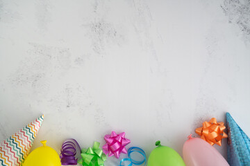 Birthday party flat lay composition, with colorful balloons, cone hats, bows, and ribbons. Top view...