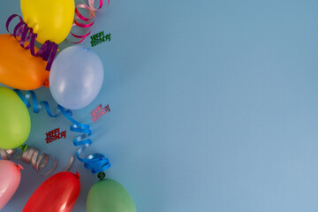 Birthday party composition, with colorful balloons and ribbons. Flat lay concept with copy space on...