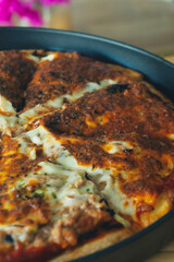 Tasty pizza with melting buffalo mozzarella, delicious tuna and green pepper. Tasty fast food traditional on wooden board table.