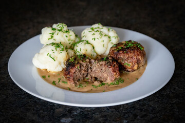 ready to eat - grilled venison burger from a charcoal grill with cauliflower, sauce and chives