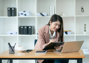 Fototapeta na wymiar Asian businesswoman talking on the phone, working through a laptop, talking to customers online.