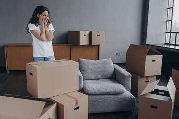 Fototapeta premium New first home, relocation. Female homeowner feels happiness standing in empty room on moving day