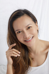 Fototapeta premium Asian woman working on a computer in bed