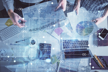 Double exposure of man and woman working together and data theme hologram drawing. Computer background. Top View.