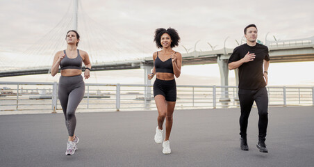 A group of people are training running fitness in the city. Use a fitness watch bracelet on the arm.