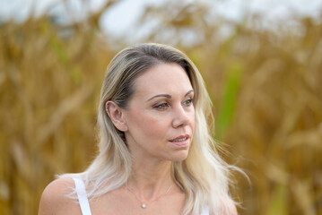 Beautiful lond woman standing in a corn field
