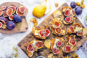 Fototapeta na wymiar top view of tasty homemade croissants with figs, pears, nuts and honey