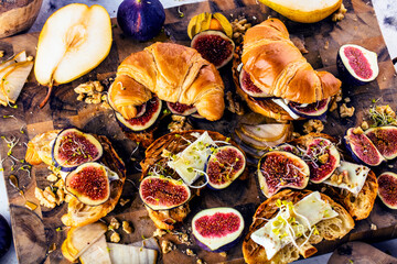 top view of tasty homemade croissants with figs, pears, nuts and honey