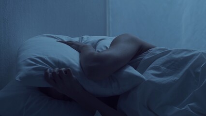 Young woman lying in the bed at night and having insomnia disease. Beautiful blond sleeping girl....