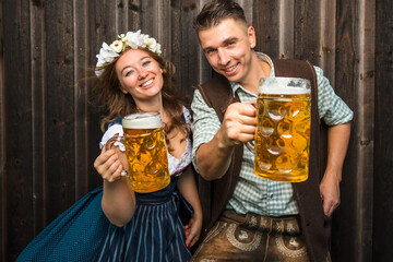 Oktoberfest, woman and man in Bavarian costume with beer mugs - 531237304