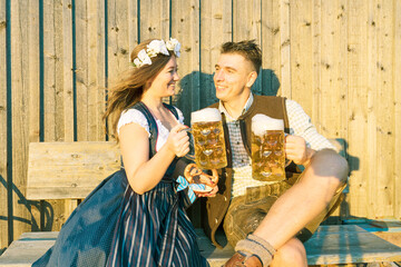 Obraz na płótnie Canvas Oktoberfest, woman and man in Bavarian costume with beer mugs