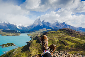 Legs of traveler sitting on a high mountain top in travel. Freedom concept. Los Cuernos rocks,...
