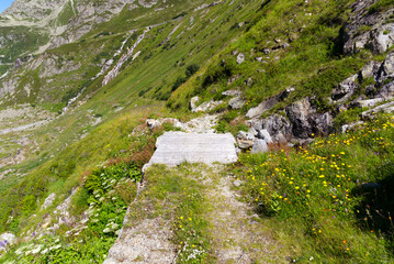Wooden bridge over mountain river at Swiss mountain pass Susten on a sunny summer day. Photo taken July 13th, 2022, Susten Pass, Switzerland.