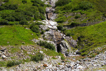 Swiss mountain pass Sustenpass with meadow and mountain river on a sunny summer day. Photo taken July 13th, 2022, Susten Pass, Switzerland.