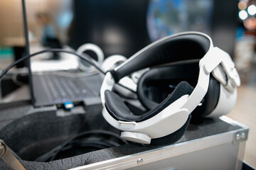 Stylish headphones and VR headset on a white table top view. Modern technology of virtual glasses. Soft focus and beautiful bokeh. Small depth of field.