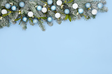Festive Christmas snow fir mistletoe tree bauble background border with white and pastel blue ball...