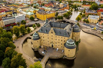 Drone shot of the beautiful Orebro Castle surrounded with Svartan river and the cityscape of Sweden